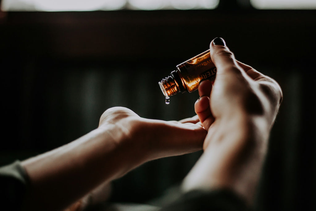 Person holding essential oil vial